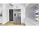Stainless steel refrigerator next to white kitchen cabinets and a window at 1416 Murray Ave, Clearwater, FL 33755