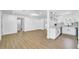 Open-concept living room with wood floors leading into a modern kitchen with white cabinets at 1416 Murray Ave, Clearwater, FL 33755