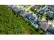 A high angle shows a neatly arranged neighborhood, landscaping, and backyard pools beside green wooded areas at 14975 Renaissance Ave, Odessa, FL 33556
