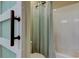 Bright bathroom featuring a tub with white tile and a glass shower door at 14975 Renaissance Ave, Odessa, FL 33556