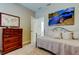 Neutral bedroom with comfortable bedding, wooden dresser, and unique wall art at 14975 Renaissance Ave, Odessa, FL 33556