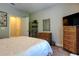 Comfortable bedroom featuring a large bed, a glass shelving unit, and neutral decor at 14975 Renaissance Ave, Odessa, FL 33556