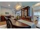 Elegant dining room showcasing an elongated wooden table, cabinet, modern lighting, and stairs to the next level at 14975 Renaissance Ave, Odessa, FL 33556