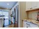 Bright kitchen with stainless steel appliances, granite countertops, white cabinetry, and sliding doors to the outdoor pool area at 14975 Renaissance Ave, Odessa, FL 33556