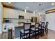 Bright kitchen features white cabinets, granite countertops, stainless steel appliances, and an island with bar seating at 14975 Renaissance Ave, Odessa, FL 33556