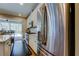 Modern kitchen featuring stainless steel appliances, granite countertops, white cabinets, and access to the outdoor patio and pool at 14975 Renaissance Ave, Odessa, FL 33556