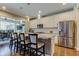 Open kitchen with granite island and countertops, white cabinets, stainless steel appliances, and seating overlooking a screened lanai at 14975 Renaissance Ave, Odessa, FL 33556