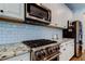 Contemporary kitchen boasts granite countertops, stainless steel appliances, white subway tile backsplash, and ample cabinet space at 14975 Renaissance Ave, Odessa, FL 33556