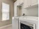 Bright laundry room with modern washer and dryer, plus built-in storage cabinets at 14975 Renaissance Ave, Odessa, FL 33556