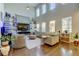 Spacious living room with high ceilings, large windows, and comfortable neutral-toned furniture, perfect for relaxation at 14975 Renaissance Ave, Odessa, FL 33556