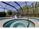 Relaxing screened-in pool and spa area with lounge chairs and wooded views for ultimate outdoor enjoyment at 14975 Renaissance Ave, Odessa, FL 33556