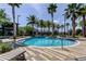 Beautiful pool area with palm trees, lounge chairs and a nearby clubhouse offering a relaxing community space at 14975 Renaissance Ave, Odessa, FL 33556