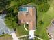 A stunning aerial view highlights a home's private backyard with a screened pool and lush greenery at 1551 Mcauliffe Ln, Palm Harbor, FL 34683