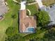 Lovely aerial view from above the home shows a manicured yard and a backyard screened pool at 1551 Mcauliffe Ln, Palm Harbor, FL 34683