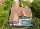 Bird's-eye view of a home showcases its inviting screened pool, spacious deck, and well-maintained roof at 1551 Mcauliffe Ln, Palm Harbor, FL 34683