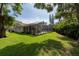 Expansive backyard featuring a screened lanai, lush green grass and mature landscaping at 1551 Mcauliffe Ln, Palm Harbor, FL 34683