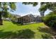 Large backyard with a screened in lanai, in-ground pool, and mature shade trees at 1551 Mcauliffe Ln, Palm Harbor, FL 34683