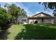 Beautiful backyard with a screened in pool, luscious green grass and tropical plants at 1551 Mcauliffe Ln, Palm Harbor, FL 34683
