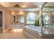 A well-lit bathroom with double sinks, a soaking tub, and a separate glass-enclosed shower at 1551 Mcauliffe Ln, Palm Harbor, FL 34683