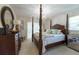 Relaxing bedroom featuring a distinctive four-poster bed and a serene atmosphere at 1551 Mcauliffe Ln, Palm Harbor, FL 34683