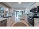 Bright white kitchen with stainless appliances, tile floors, and eat in nook at 1551 Mcauliffe Ln, Palm Harbor, FL 34683