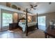 Spacious main bedroom featuring a decorative four-poster bed, wood floors, and access to the pool at 1551 Mcauliffe Ln, Palm Harbor, FL 34683