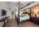 Bright main bedroom with a decorative four-poster bed, and a tray ceiling with inset shelving for décor at 1551 Mcauliffe Ln, Palm Harbor, FL 34683