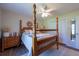 Bright main bedroom features a four-poster bed, ceiling fan, and lots of natural light at 1551 Mcauliffe Ln, Palm Harbor, FL 34683