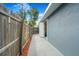 A fenced backyard entrance featuring a cement pathway and landscaping at 1625 Fulton Ave, Clearwater, FL 33755