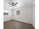 A modern bedroom with gray floors, white walls, ceiling fan, and natural light from two windows at 1625 Fulton Ave, Clearwater, FL 33755