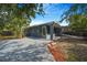 Charming blue home features a spacious driveway, covered entryway, and well-maintained landscaping at 1625 Fulton Ave, Clearwater, FL 33755