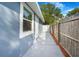 Home exterior featuring a blue painted exterior, a door, and a wooden fence at 1625 Fulton Ave, Clearwater, FL 33755