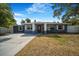 Inviting blue house featuring a well-manicured lawn, new driveway, and a welcoming front entry at 1625 Fulton Ave, Clearwater, FL 33755