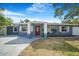 Charming single-story home featuring a red front door, shuttered windows, and a well-manicured lawn at 1625 Fulton Ave, Clearwater, FL 33755