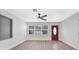 Bright, open living room with modern ceiling fan, wood flooring, and natural light from large windows at 1625 Fulton Ave, Clearwater, FL 33755