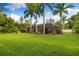 Expansive backyard featuring lush greenery, tropical landscaping, and a screened lanai at 17347 Linda Vista Cir, Lutz, FL 33548