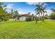 Expansive backyard with lush green grass, tropical trees, and white fencing at 17347 Linda Vista Cir, Lutz, FL 33548
