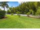 Lush backyard featuring manicured lawn, white fence, and privacy bamboo at 17347 Linda Vista Cir, Lutz, FL 33548