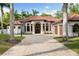 Beautiful exterior of home featuring a tile roof, arched entryway, and a paver driveway at 17347 Linda Vista Cir, Lutz, FL 33548