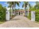 Stunning exterior of home with a tile roof, arched entryway, and palm tree lined paver driveway at 17347 Linda Vista Cir, Lutz, FL 33548