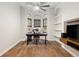 Bright home office featuring hardwood floors, built-in shelving, modern desk setup, and lots of natural light at 17347 Linda Vista Cir, Lutz, FL 33548