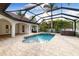 Inviting pool with spa, tile decking and screened-in enclosure offers a private oasis surrounded by lush foliage at 17347 Linda Vista Cir, Lutz, FL 33548