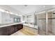 Well-lit bathroom with a double sink vanity, soaking tub, and a glass-enclosed shower at 17529 Buckingham Garden Dr, Lithia, FL 33547