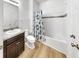 Cozy bathroom with wood-look floors, a neutral-toned vanity, tub, and a decorative shower curtain at 17529 Buckingham Garden Dr, Lithia, FL 33547