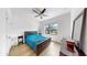 Bright bedroom with a ceiling fan, light wood floors, and a large window for plenty of natural light at 17529 Buckingham Garden Dr, Lithia, FL 33547