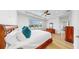Bright bedroom featuring a wooden bed frame, white linens, large windows, and wood flooring at 17529 Buckingham Garden Dr, Lithia, FL 33547