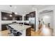 Bright kitchen boasts an island with bar seating, stainless steel appliances, granite countertops, and dark cabinets at 17529 Buckingham Garden Dr, Lithia, FL 33547