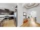 Modern kitchen with stainless steel appliances and dark wood cabinets, leading to the home's entryway at 17529 Buckingham Garden Dr, Lithia, FL 33547