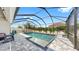Private screened-in pool with a sun shelf and surrounding patio with ample space for entertaining and lounging at 17529 Buckingham Garden Dr, Lithia, FL 33547