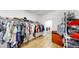 Spacious walk-in closet with wood floor, organized shelving, and ample storage for clothes and accessories at 17529 Buckingham Garden Dr, Lithia, FL 33547